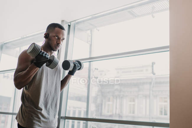 Homme noir avec haltères dans la salle de gym — Photo de stock