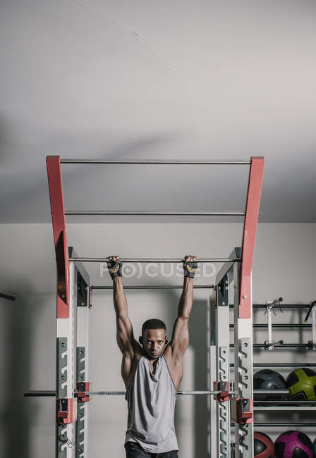 Schwarzer hängt an Bar im Fitnessstudio — Stockfoto
