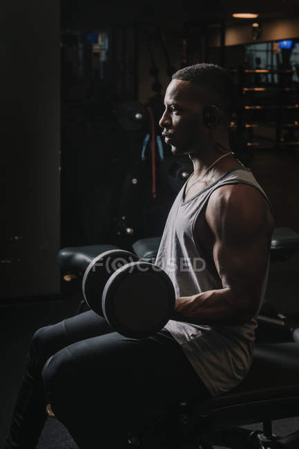 Black guy exercising with dumbbells in gym — Stock Photo