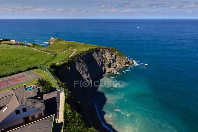 Hermosa vista al dron de villa de lujo situada en el borde del acantilado cerca del majestuoso mar azul - foto de stock