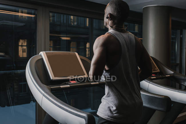 Black man running on treadmill in gym — Stock Photo