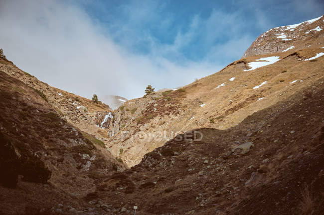 Nuvem sobre montanhas cênicas rochosas na natureza — Fotografia de Stock