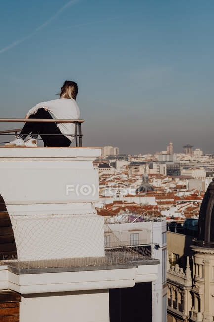 Attractive woman sitting on roof — Stock Photo