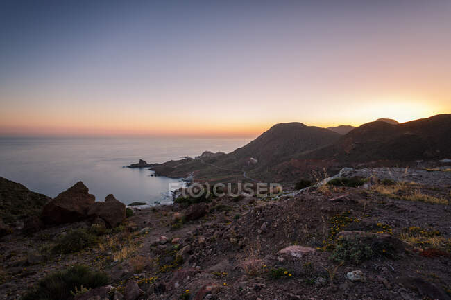 Incrível costa rochosa de mar calmo durante o magnífico pôr do sol — Fotografia de Stock