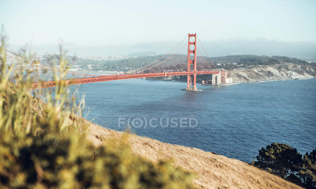 From above red bridge above sea near hill and cityscape in sunny day in San Francisco, USA — Stock Photo