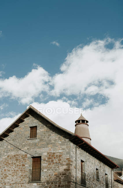 De dessous tour près de construction en brique et ciel bleu dans les nuages dans les Pyrénées — Photo de stock