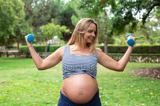 Allenamento donna attraente incinta con manubri — Foto stock