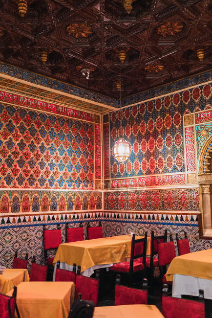 Прекрасная комната кафе со столами и стульями и стенами, украшенная мозаикой — стоковое фото