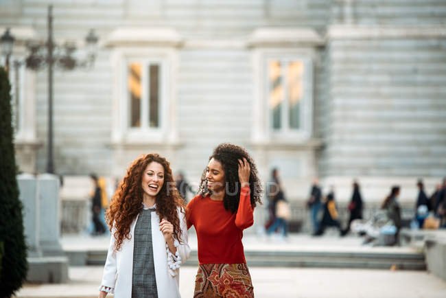 Dos jóvenes alegres paseando por las calles de Madrid en invierno - foto de stock