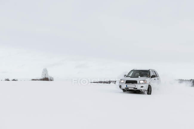 Auto fährt auf Schneefeld — Stockfoto