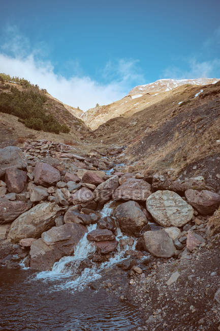 Piccolo ruscello sulla collina sassosa in montagna — Foto stock