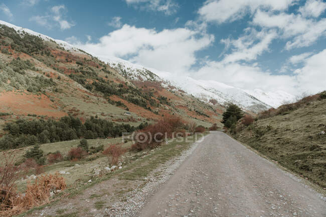 Rota do campo no vale com bosques e montanhas maravilhosas na neve em Pirenéus — Fotografia de Stock