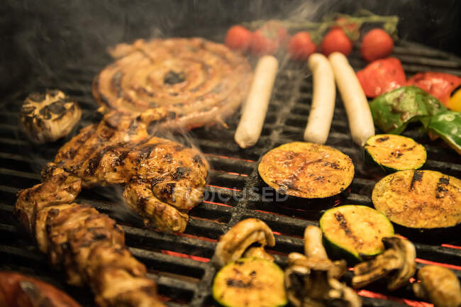 Fatias de close-up de legumes variados e fritura de carne na grelha quente — Fotografia de Stock