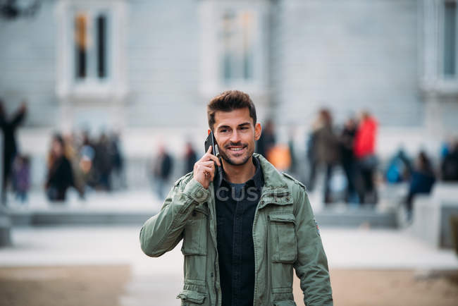 Молодий чоловік на мобільному телефоні і під час зими блукає божевільною — стокове фото