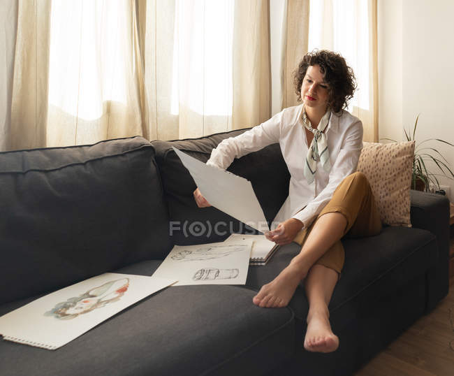 Mujer con dibujos en papeles - foto de stock