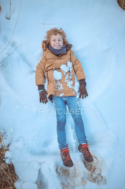 Niño acostado en la cima de la colina - foto de stock
