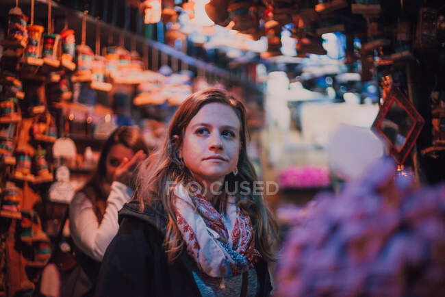 Giovane donna turistica riflessiva in piedi sul mercato orientale con decorazioni a Chefchaouen, Marocco — Foto stock