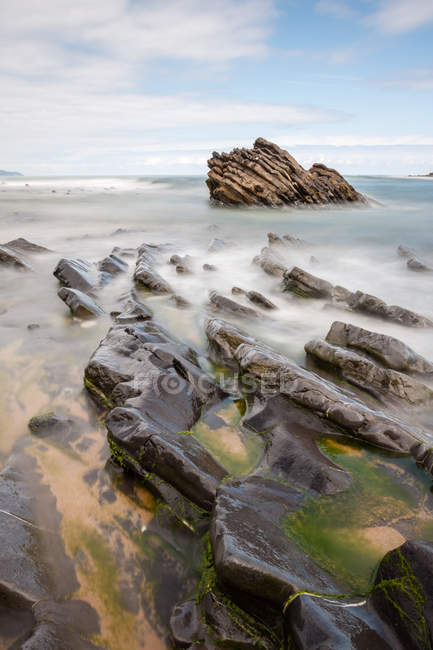 Чудовий море прокатки біля берега на Похмурий день — стокове фото