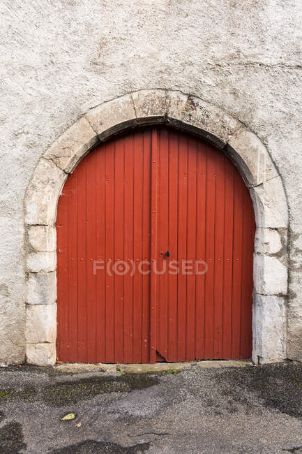 Vecchia costruzione con porta rossa in un villaggio di campagna nei Pirenei — Foto stock
