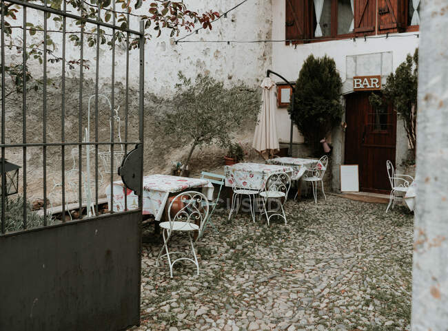 Двор со столами и стульями возле старого здания бара в Пиренеях — стоковое фото