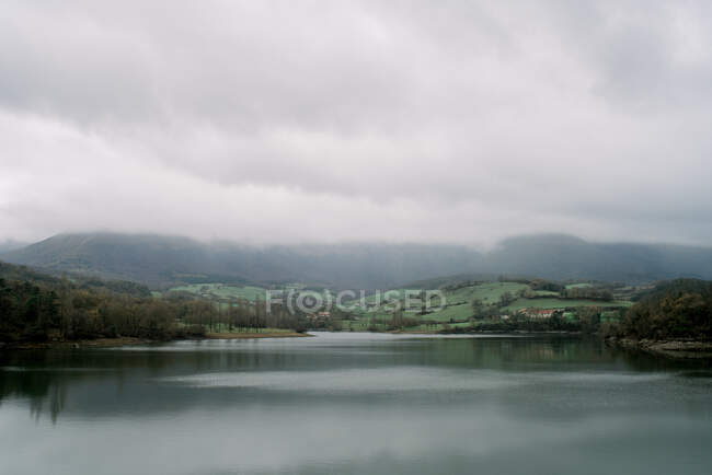 Malerischer Blick auf den See zwischen Pflanzen und Bergen bei regnerischem Wetter in orduna, Spanien — Stockfoto