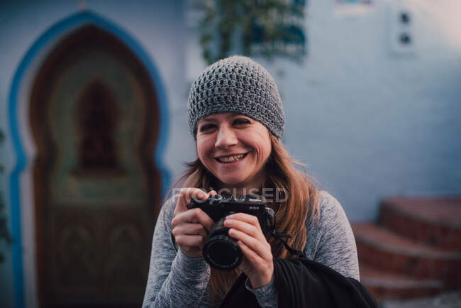 Смеющаяся женщина с камерой — стоковое фото
