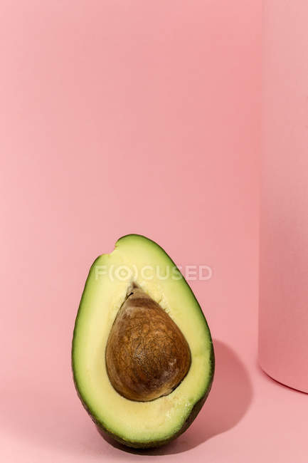 Metà fresca di avocado su sfondo rosa — Foto stock