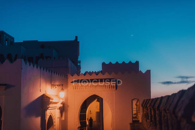 Antiguo edificio de piedra caliza iluminado por la noche en Chefchaouen, Marruecos - foto de stock