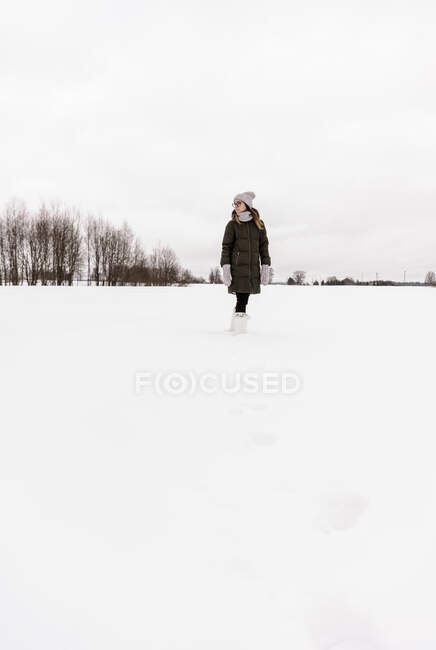 Mulher pulando entre o campo de neve — Fotografia de Stock