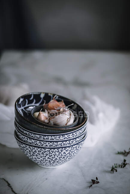Closeup of ornamental bowls with unpeeled garlic for cooking vigil potaje dish — Stock Photo