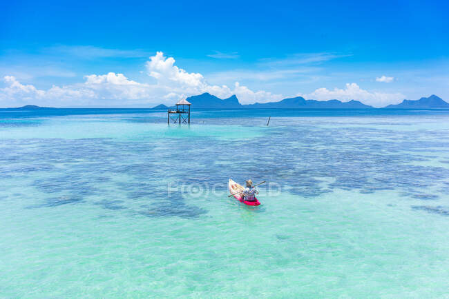 Vista posteriore barca maschile in canoa con pagaia sul mare azzurro incredibile e cielo blu in Malesia — Foto stock