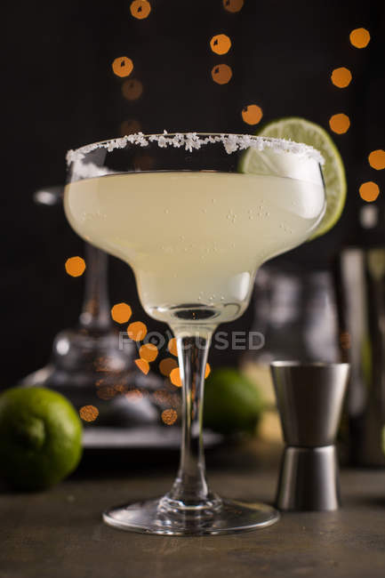 Glass of margarita cocktail on dark background with lights — Stock Photo