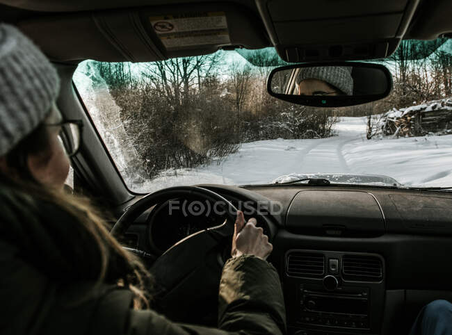 Женщина водит машину по снежному полю — стоковое фото