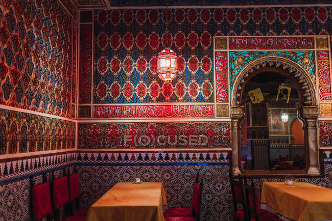 Magnifique salle de café avec tables et chaises et murs décorés de mosaïque — Photo de stock
