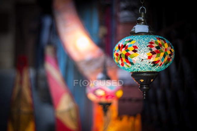 Lanterna estampada colorido com padrão muito brilhante pendurado perto da entrada do edifício no fundo borrado da rua — Fotografia de Stock