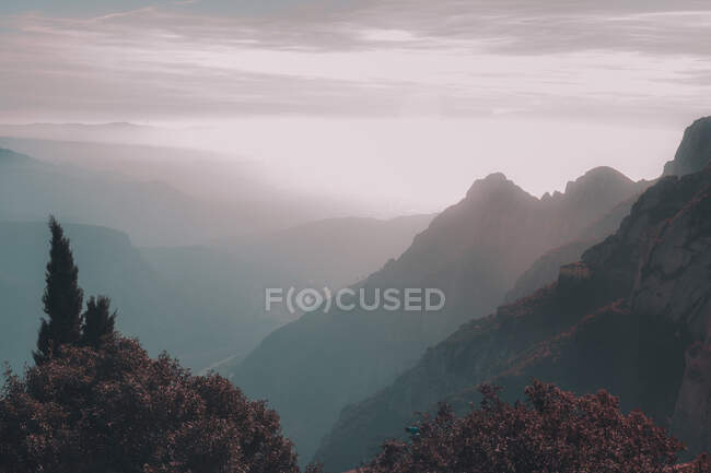 Pintoresca vista de las cimas de las montañas de piedra, valle y cielo nublado - foto de stock