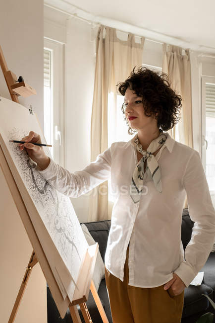 Woman drawing city on canvas — Stock Photo
