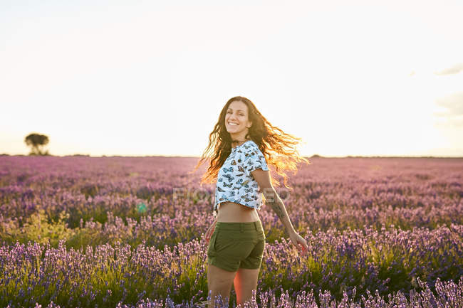 Lächelnde junge Frau wirbelt im großen violetten Lavendelfeld — Stockfoto