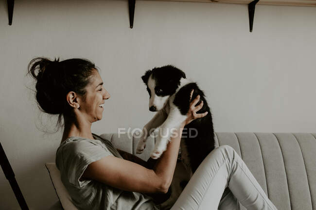Дівчина-підліток з милим цуценям на дивані — стокове фото