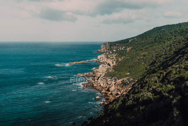 Felsige Küste und ruhiges blaues Meerwasser — Stockfoto