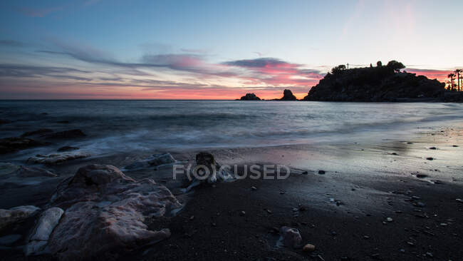 Amazing rocky coast of calm sea during magnificent sunset — Stock Photo