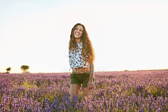 Молода жінка посміхається між фіолетовим лавандовим полем — стокове фото