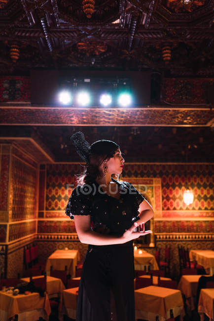 Молодая женщина в платье танцует фламенко на сцене в роскошной восточной комнате, украшенной мозаикой — стоковое фото