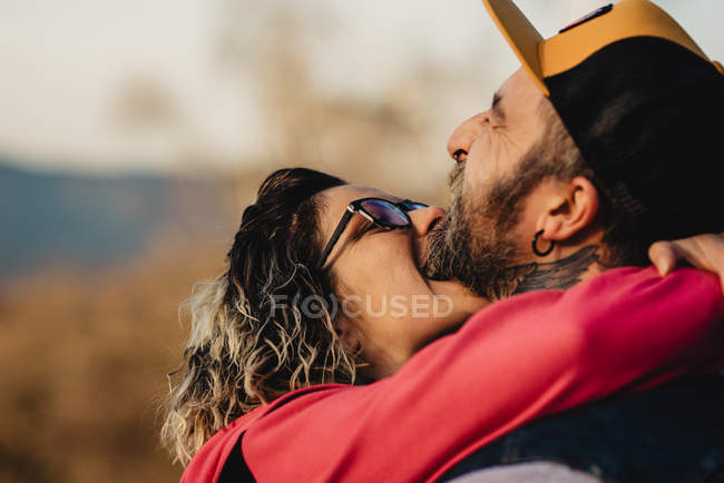 Girlfriend biting boyfriend neck in forest — Stock Photo