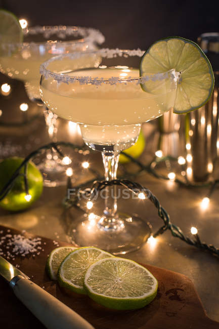 Glasses of margarita cocktail on dark background with lights — Stock Photo