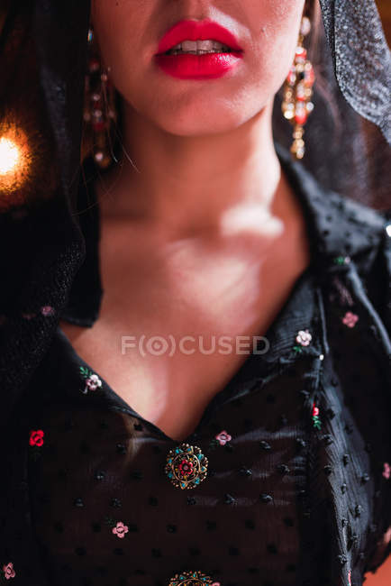 Imagen recortada de la mujer en velo y vestido en escena iluminada por luces sobre fondo borroso - foto de stock