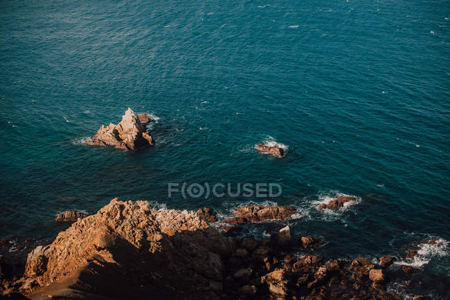 Rocky coast and calm blue sea water — Stock Photo