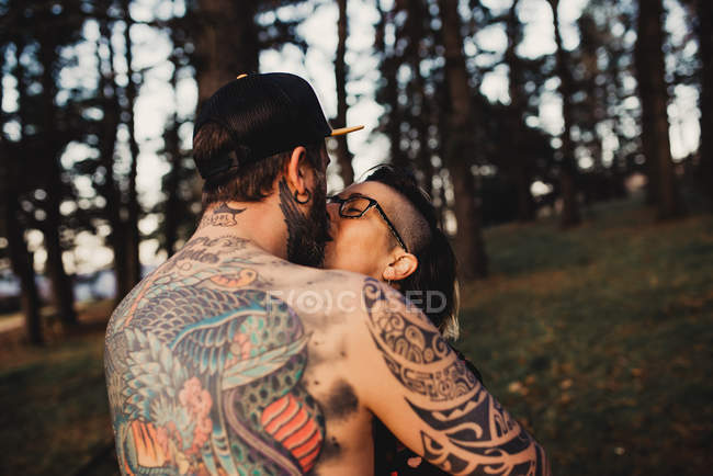 Feliz pareja besándose en el tiempo soleado - foto de stock