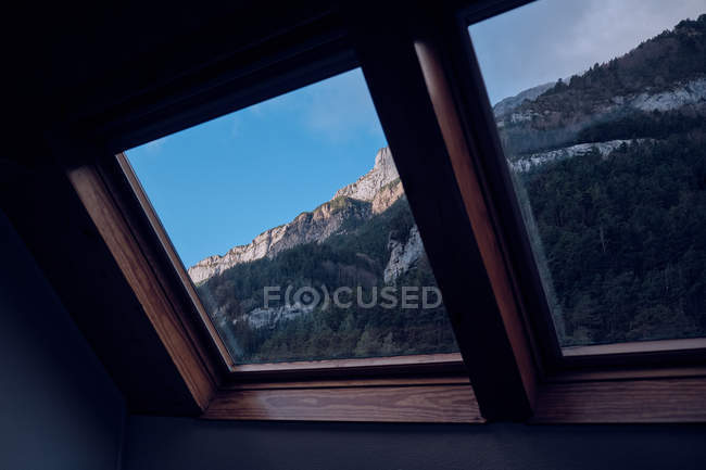 Pintoresca vista de la ladera de la montaña en el día soleado a través de la ventana de la casa de campo - foto de stock