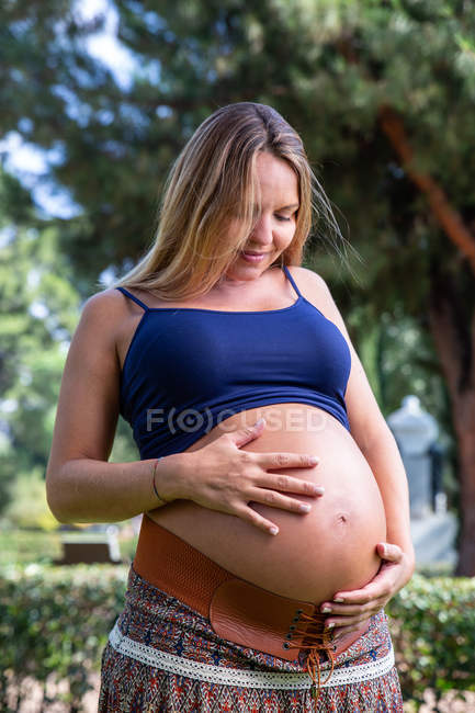 Smiling pregnant attractive woman in park — Stock Photo